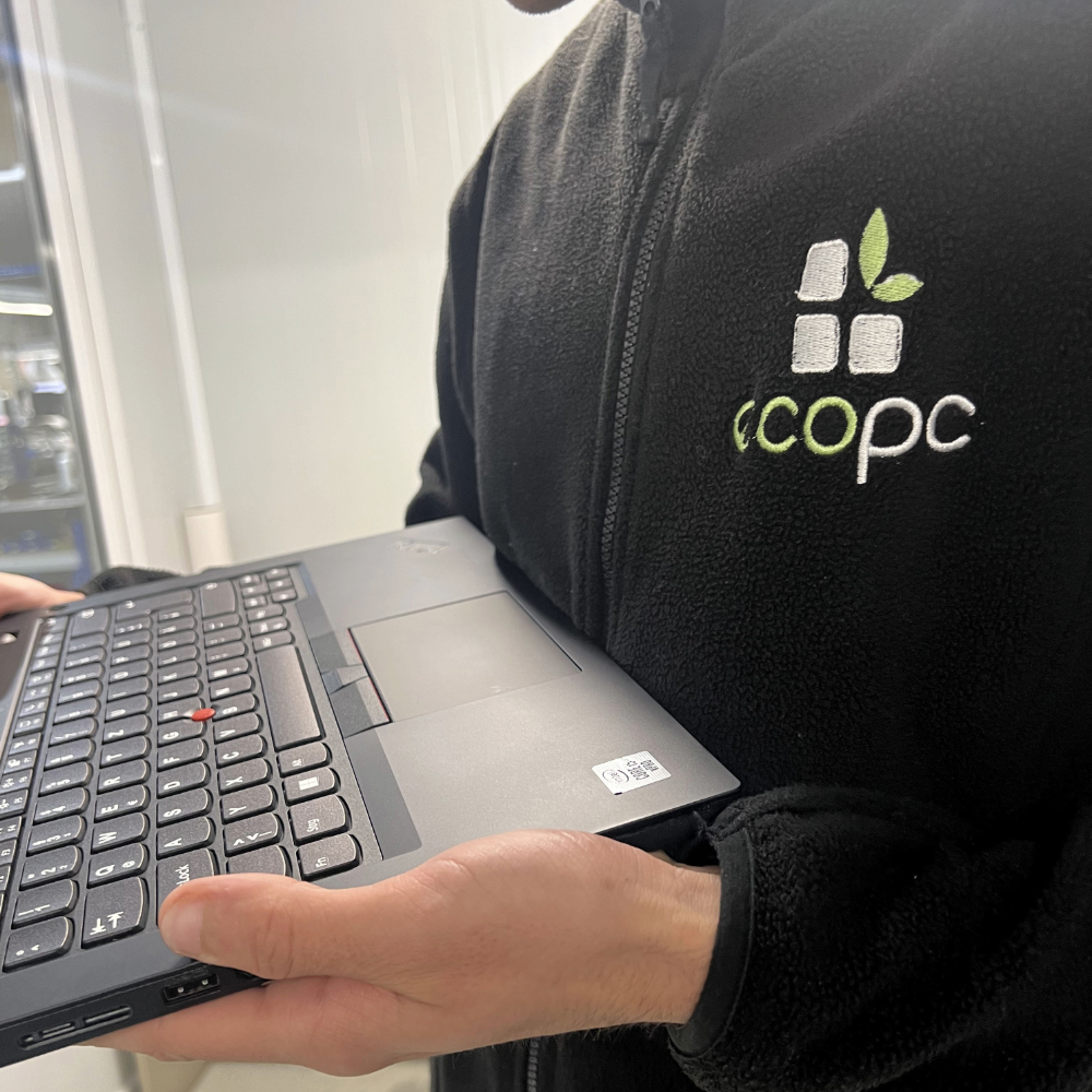 Técnico de EcoPC sujetando un portátil reacondicionado con teclado español premium
